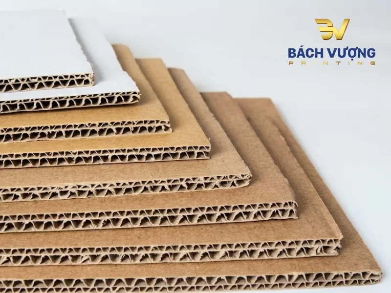 Giấy carton s&oacute;ng nhiều lớp m&agrave;u trắng v&agrave; n&acirc;u xếp với phần m&eacute;p cắt c&oacute; kết cấu l&otilde;i s&oacute;ng uốn lượn giảm chấn tăng dần về độ d&agrave;y